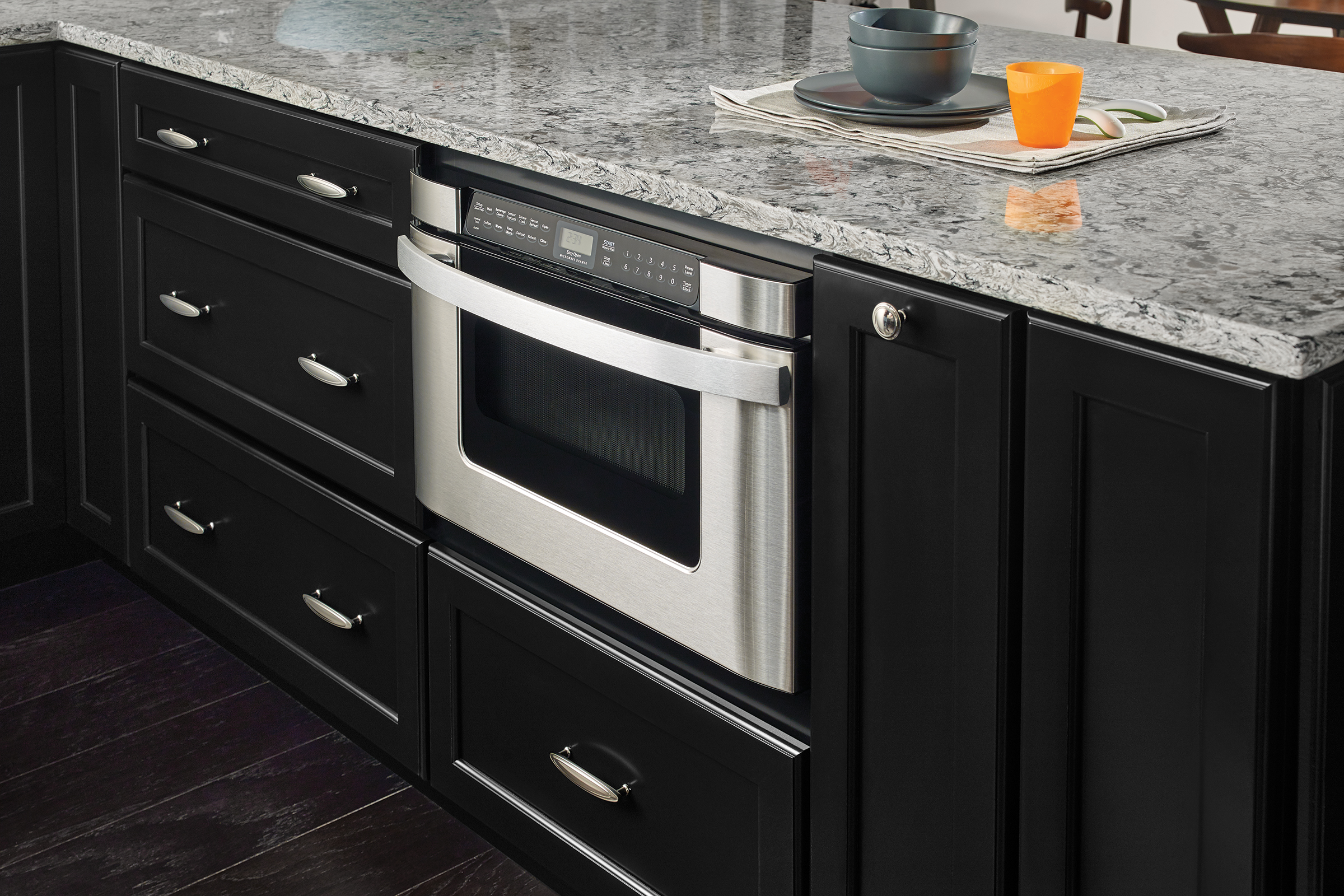 Under-the-counter microwave installed in kitchen peninsula with KraftMaid cabinets