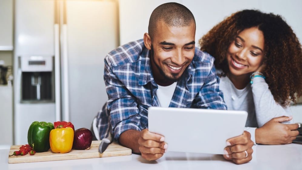 Couple using a white tablet computer to look for kitchen design inspiration