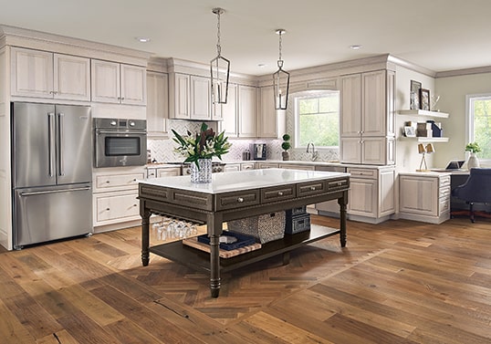 Traditional KraftMaid kitchen in Translucent Limestone finish with furniture island in Weathered Tavern finish