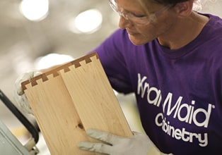 Cabinetmaker wearing KraftMaid Cabinetry shirt assembling a dovetail drawer