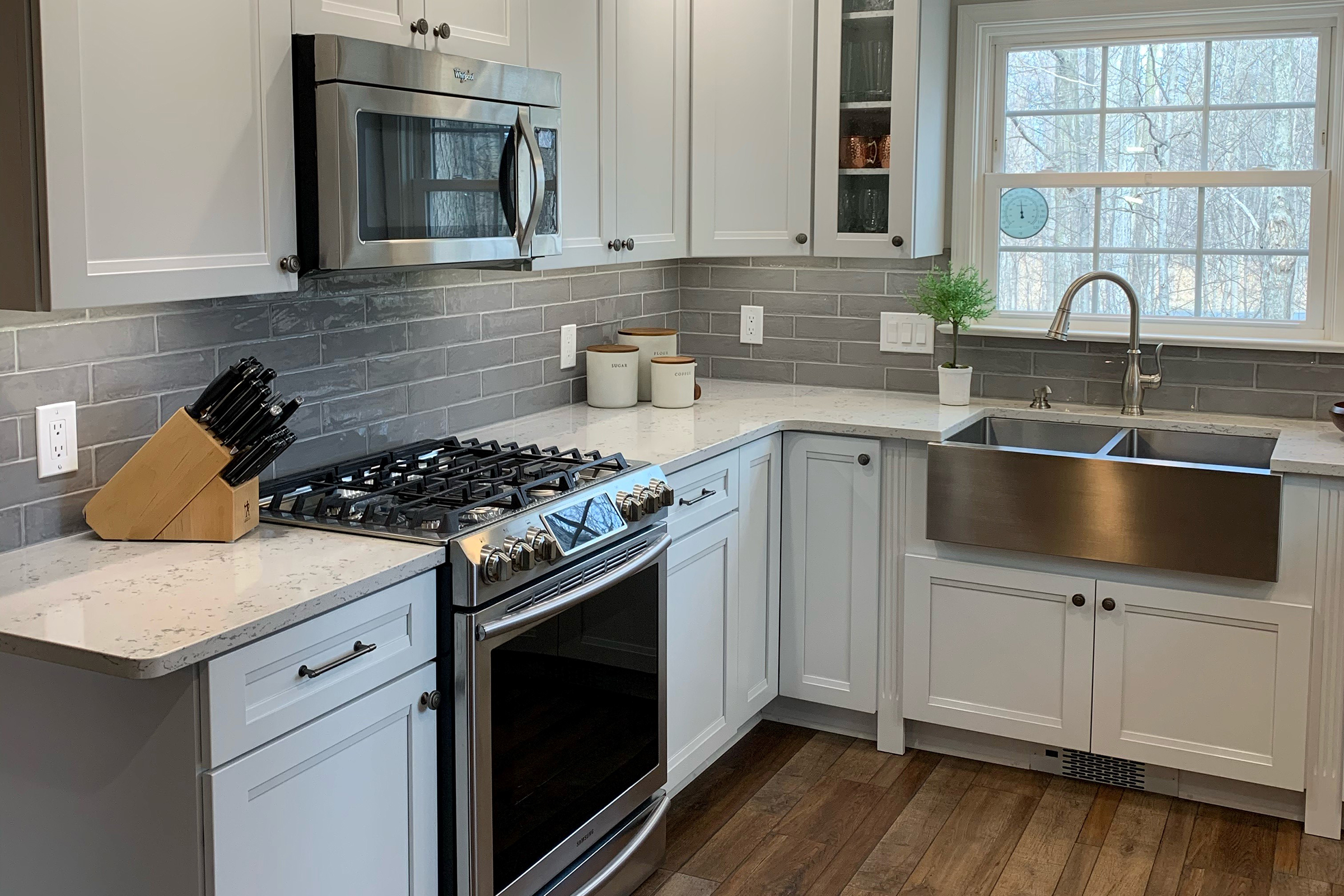 Cabinet-undermount microwave in a kitchen with KraftMaid Dove White cabinets and stainless steel appliances